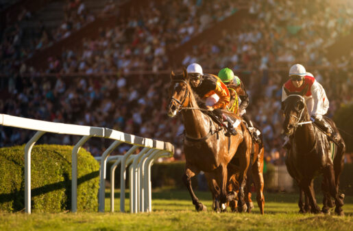 Jockeys racing horses around a track.